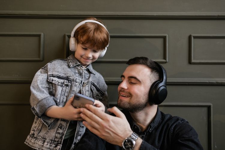 niño con su padre escuchando musica con auriculares